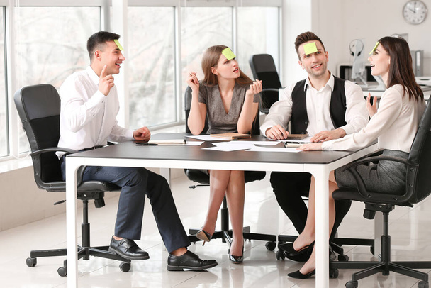 Команда бизнесменов, играющих в офисную игру "Кто я"
 - Фото, изображение