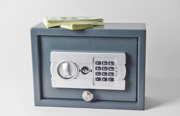Сучасний сейф з доларовими банкнотами на світлому фоні
 - Фото, зображення
