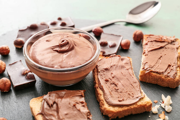 Friss kenyér és csokoládé paszta palatáblán, közelkép - Fotó, kép