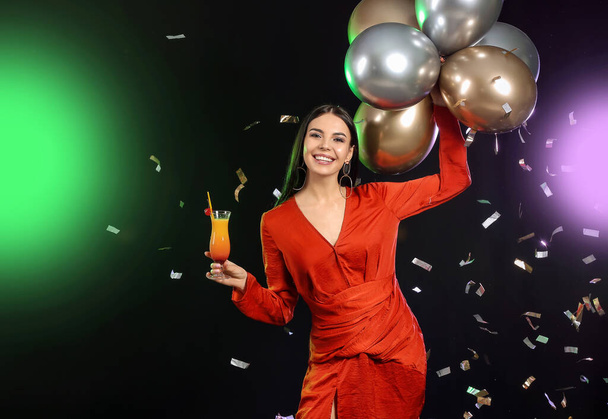 Kokteyl ve balonlarla dolu mutlu genç bir kadın. - Fotoğraf, Görsel