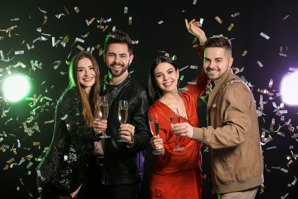 Happy people with glasses of champagne on dark background - Foto, Imagen