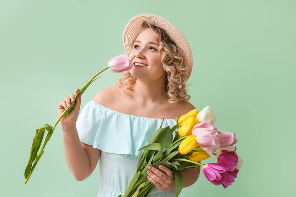 Beautiful young woman with bouquet of flowers on color background - Foto, immagini