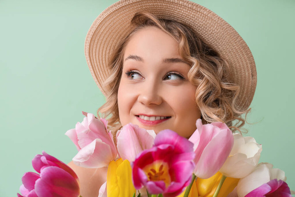 Beautiful young woman with bouquet of flowers on color background - Photo, Image