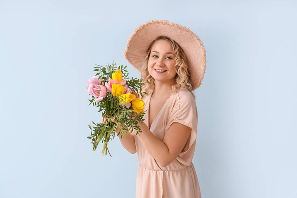 Beautiful young woman with bouquet of flowers on color background - Fotoğraf, Görsel
