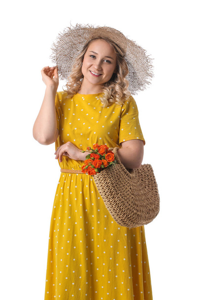 Beautiful young woman with bag and flowers on white background - Foto, afbeelding