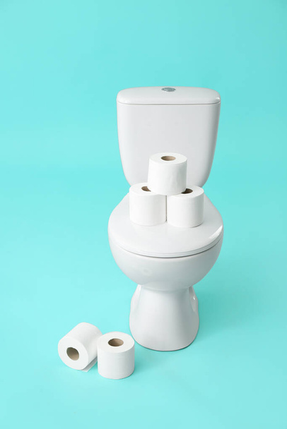 Toilet bowl with rolls of paper on color background - Foto, immagini