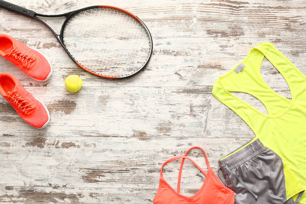 Αθλητικά ρούχα και ρακέτα τένις σε ξύλινο φόντο - Φωτογραφία, εικόνα