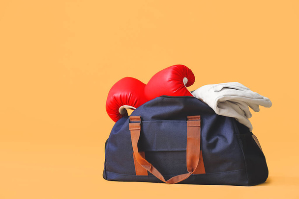 Tas met sportkleding en uitrusting op kleur achtergrond - Foto, afbeelding