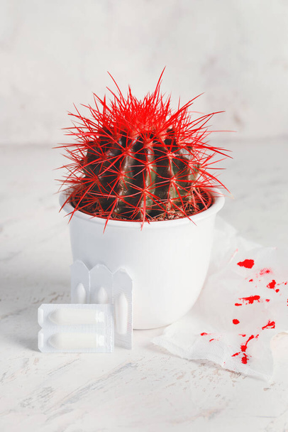 Kaktus, papier toaletowy z plamami krwi i czopkami hemoroidalnymi na jasnym tle - Zdjęcie, obraz