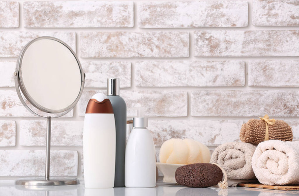 Géis de chuveiro, toalhas, espelho e loofah no banheiro
 - Foto, Imagem