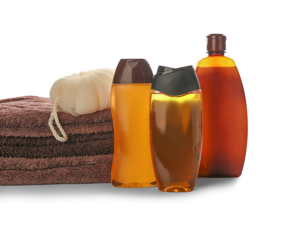 Shower gels, towel and loofah on white background - Foto, afbeelding