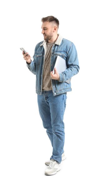 Nuori mies kannettava tietokone ja matkapuhelin valkoisella taustalla - Valokuva, kuva