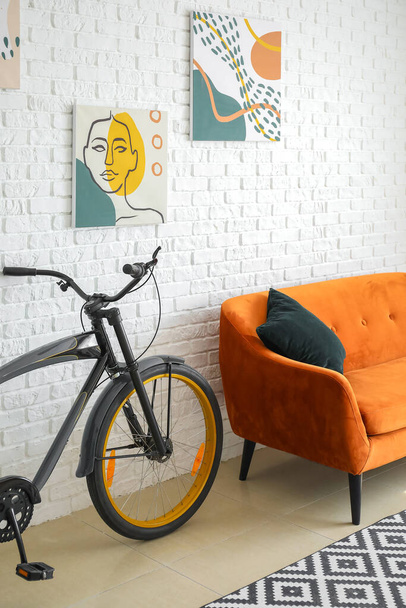 Interior of modern living room with comfortable sofa and bicycle - 写真・画像