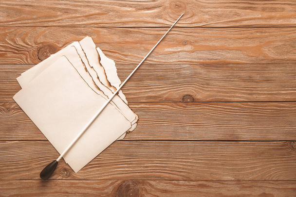 Note sheets and conductor's stick on wooden background - Photo, Image