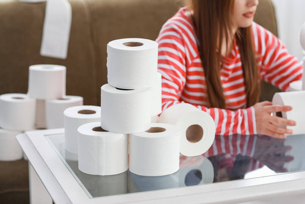 Woman with heap of toilet paper at home. Concept of coronavirus epidemic - Photo, Image
