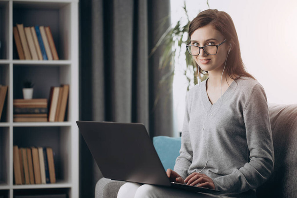Charming girl in eyeglasses spending free time with laptop - Φωτογραφία, εικόνα