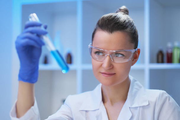 A female medical scientist works in a laboratory. Spcialist conducts experiments, develops auccin auctin from the virus. Coronavirus covid-19. - Foto, Bild