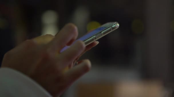 4K Закройте азиатские руки с помощью мобильного сенсорного экрана сотового телефона ночью в городе с цветовым фоном. Серфинг в интернете, проверка социальных сетей и написание текста на смартфоне - Дэн
 - Кадры, видео