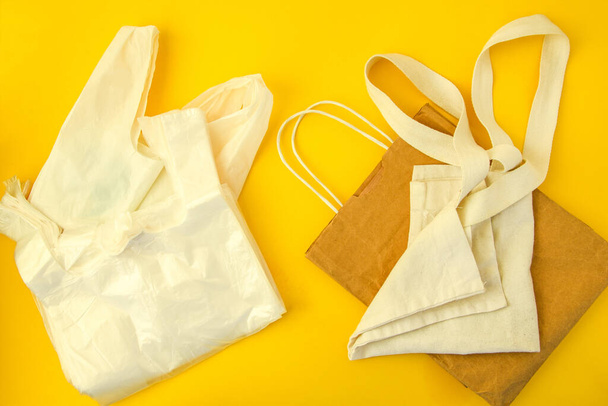 Salvar planeta. Tela de lino reutilizable natural y bolsas de papel artesanales para comprar bolsas de plástico VS. Fondo de estilo de vida ecológico. Ningún concepto de elección de contaminación
 - Foto, Imagen