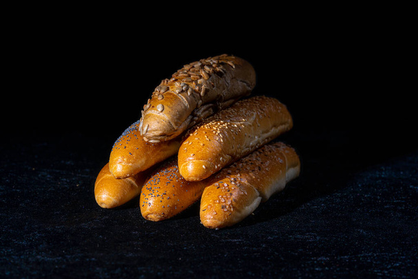 Fresh rolls on dark background. Poppy seed roll and sesame seed roll. Typical popular czech breakfast rolls or buns. Part of continental breakfast or Czechbreakfast. - Photo, Image