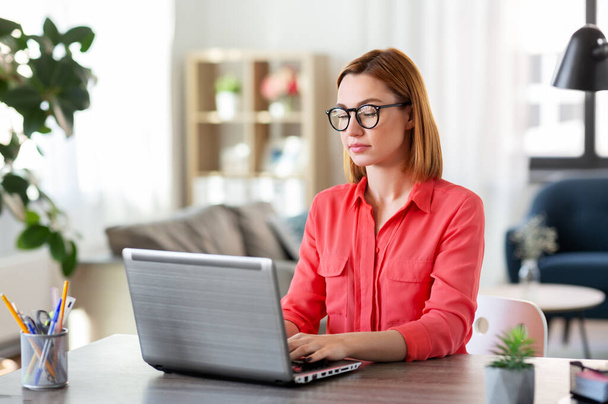 woman with laptop working at home office - Foto, Bild