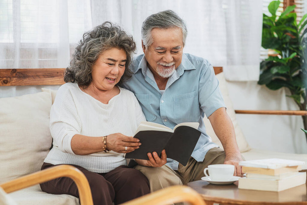 Azjatycka para Dziadkowie siedzi i czyta książkę wraz ze szczęśliwym uczuciem w domu, Niech żyje i starsze społeczeństwo, Ciepła rodzina i szczęście, covid19 wybuchu epidemii i koncepcji dystansu społecznego - Zdjęcie, obraz