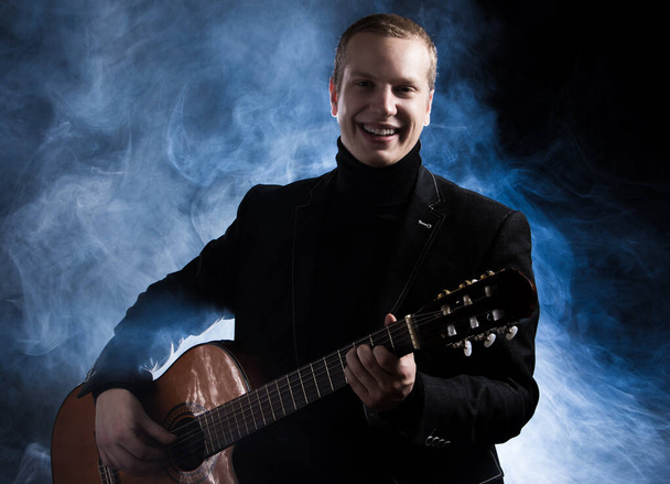 Musik. Musiker im schwarzen Anzug mit Gitarre - Foto, Bild