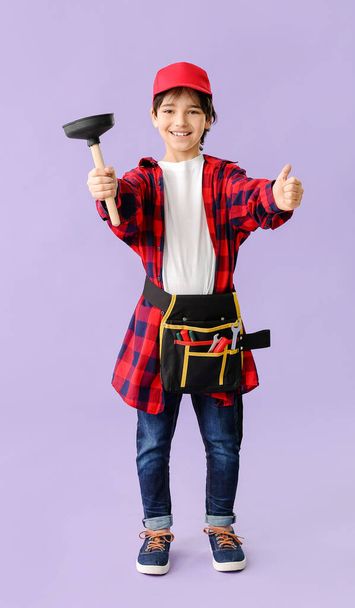 Portrait of little plumber showing thumb-up gesture on color background - Fotografie, Obrázek