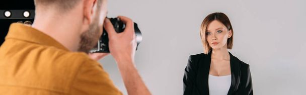 Panoráma felvétel gyönyörű modell pózol fotós digitális fényképezőgép a fotó stúdióban   - Fotó, kép