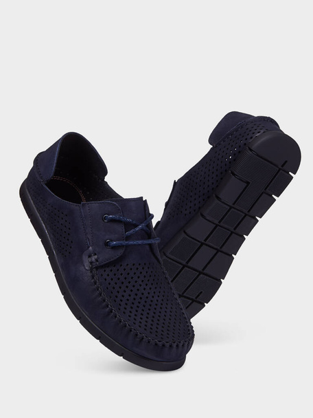 Zapatos de verano de gamuza azul para hombre con perforación y suela elástica negra. Aislado sobre un fondo blanco
. - Foto, Imagen