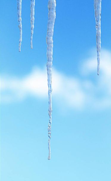 IJspegels van ijs tegen een blauwe lucht met wolken. - Foto, afbeelding
