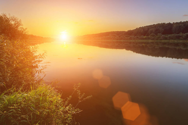 Вид на прекрасний захід сонця над річкою в осінній вечір. Ландшафтний
. - Фото, зображення