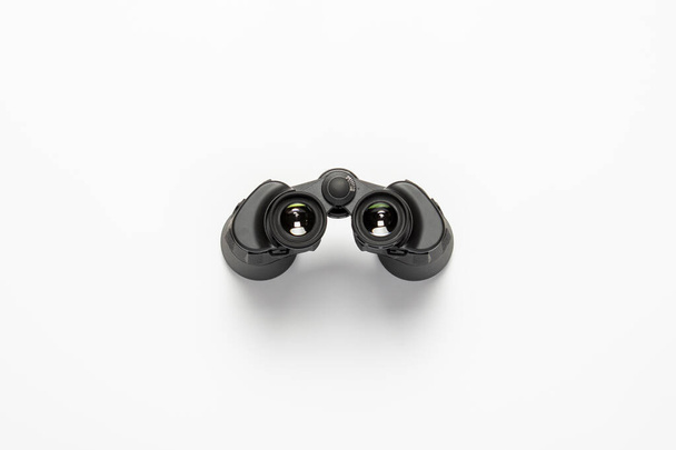 Black binoculars on a white background. Flat lay, top view. - Photo, Image