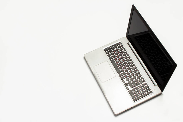 Laptop, világos fehér háttérrel. Technológiai koncepció. Lapos fekvésű, felülnézet. - Fotó, kép
