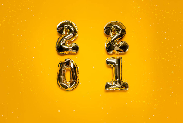 Golden balloons on bright yellow background with bokeh and sparkles. Wishlist with resolution and new year concept. Top horizontal view background - Фото, зображення