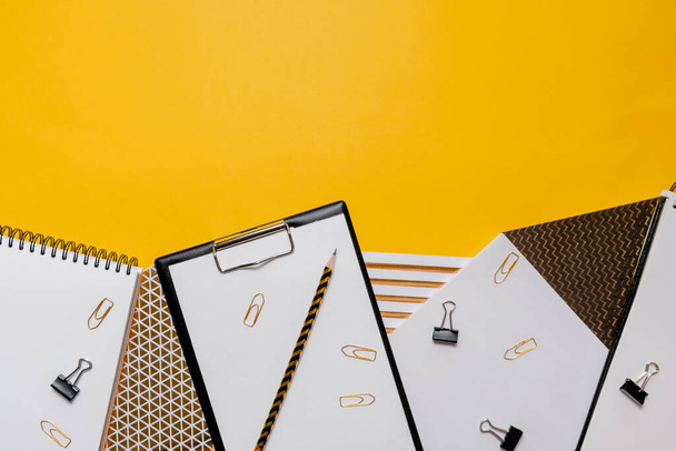 Mockup planner flat lay, top horizontal view yellow background. Notepad and notebooks with stationery. Golden, white and black colors. Back to school, education concept. - Fotó, kép