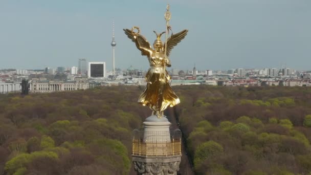 AERIAL: Close Up Dolly of Berlin Victory Column Golden Statue Victoria in het prachtige zonlicht en Berlijn, Duitsland City Scape Skyline op de achtergrond  - Video