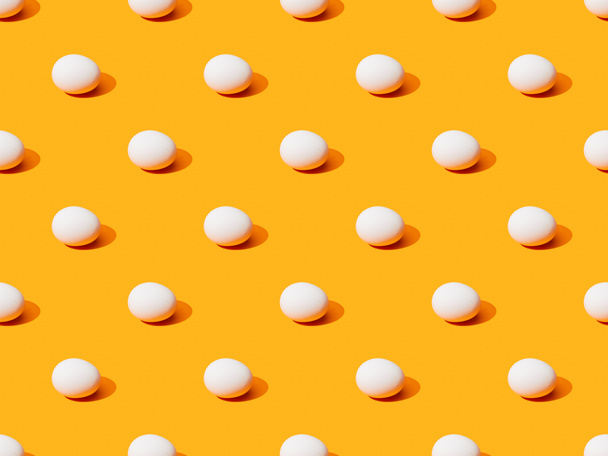 fresh white chicken eggs on orange colorful background, seamless pattern - Fotó, kép
