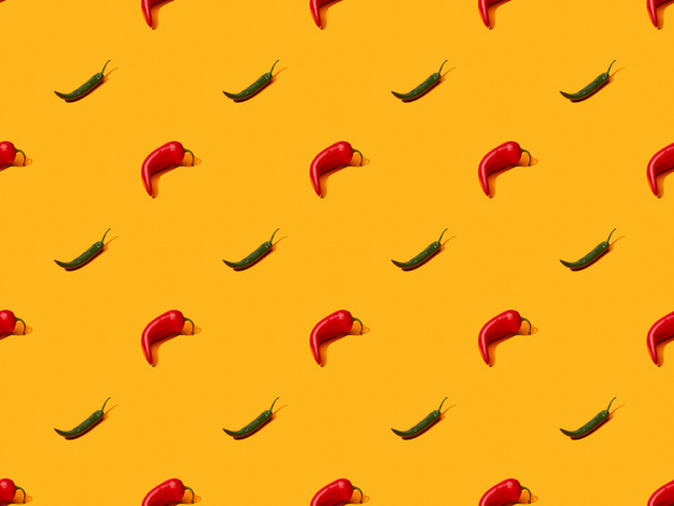 red spicy chili peppers and jalapenos on orange colorful background, seamless pattern - Foto, afbeelding