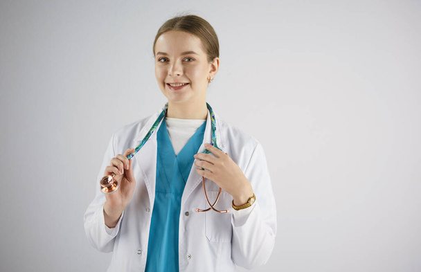Женщина-врач со стетоскопом стоит в кабинете
 - Фото, изображение