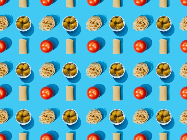 top view of fresh pasta with olives, tomatoes on blue background, seamless pattern - Foto, Imagem