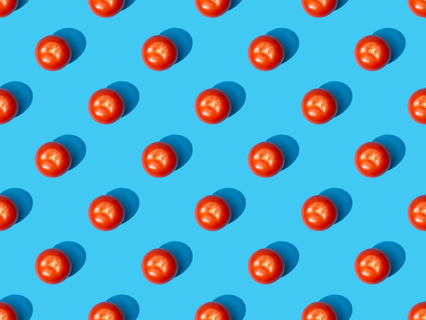 top view of fresh tomatoes on blue colorful background, seamless pattern - 写真・画像
