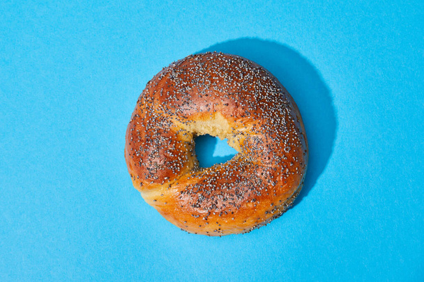 top view of fresh baked bun on blue background - Zdjęcie, obraz