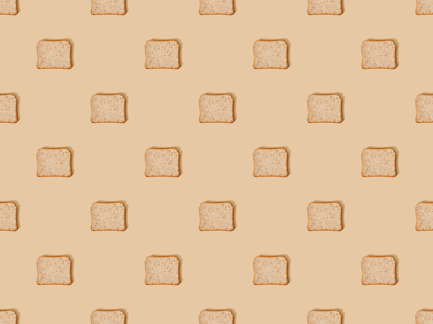 top view of fresh toast bread on beige background, seamless pattern - 写真・画像