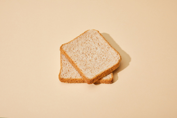 fresh toast bread slices on beige background - Foto, afbeelding
