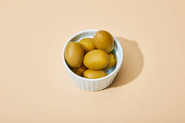 olives in bowl on beige background with copy space - Zdjęcie, obraz
