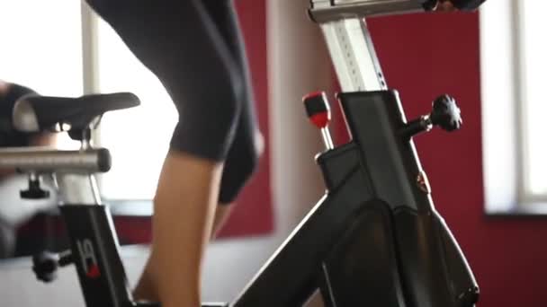 Fille sportive utilisant un équipement d'exercice dans une salle de gym sombre moderne. Fitness sur une pédale de vélo. jambes femelles sur le gros plan de la pédale. Style de vie sain et concepts sportifs. Femme sur le cycle
  - Séquence, vidéo
