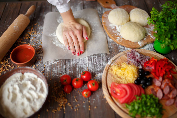 woman kneads the dough with hands while cooking - Foto, Bild
