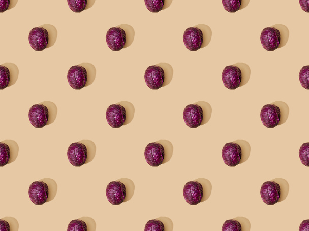 top view of whole ripe red cabbage on beige background, seamless pattern - Foto, immagini