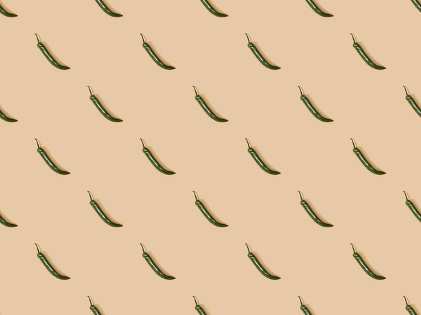 top view of jalapenos on beige background, seamless pattern - 写真・画像